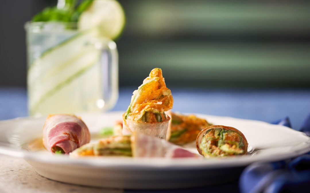 Fiori di zucca fritti avvolti con pancetta arrosto piccante e gocce di olio emulsionato con basilico